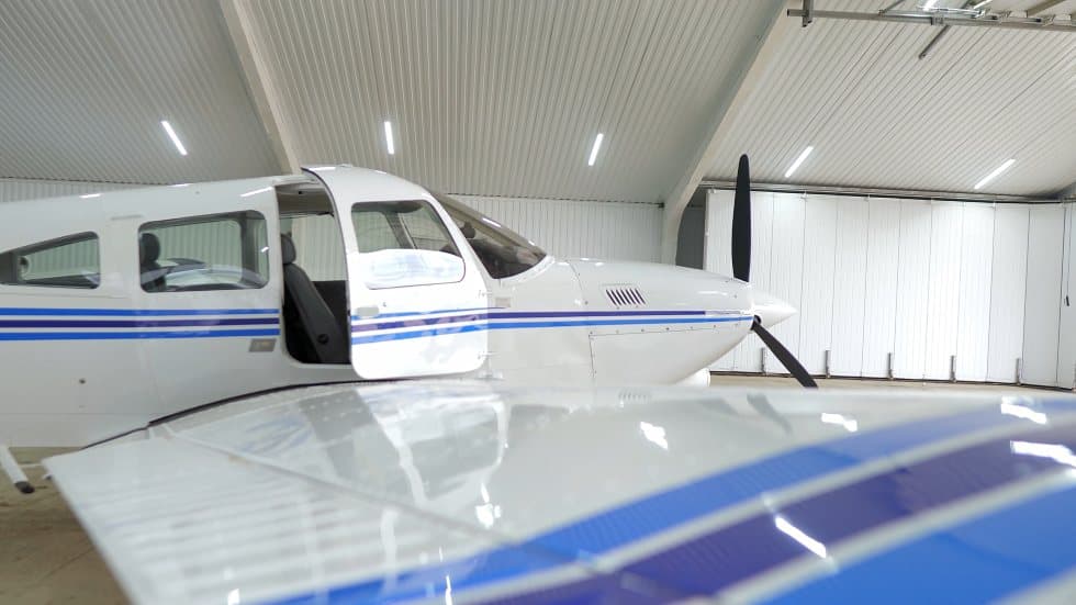 Piston aircraft positioned in a bright hangar